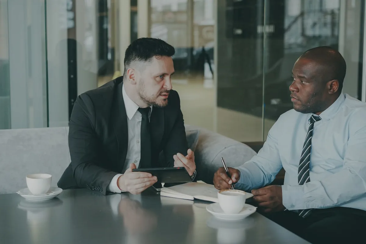 A friendly intake specialist meeting with a prospective client over coffee.